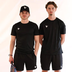 Two men wearing black athletic outfits with a logo, standing side by side against a plain background.