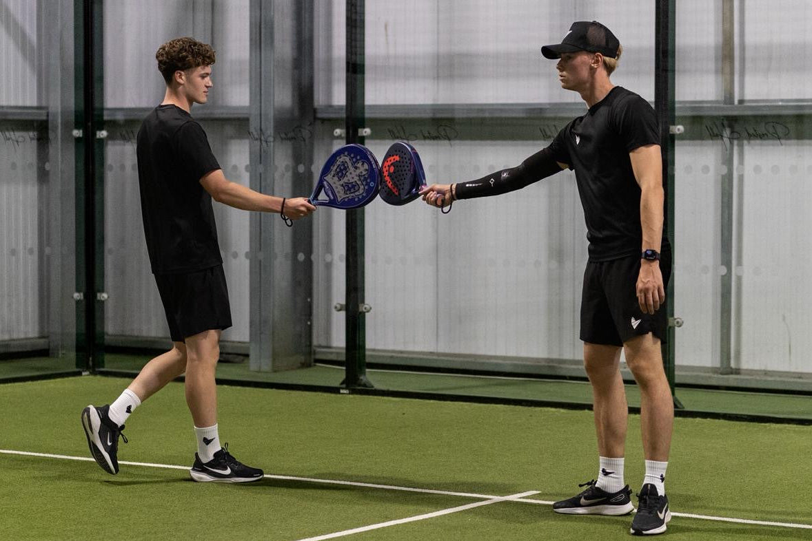 Two people on a padel court wearing the Padel Source Pro Collection
