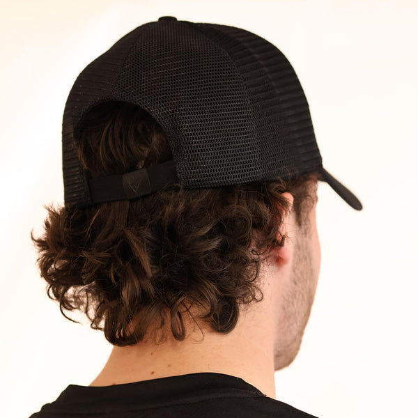 Person wearing a black mesh Padel Source Pro Performance cap from behind on a white background