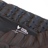 Black athletic shorts with a white logo on a neutral background